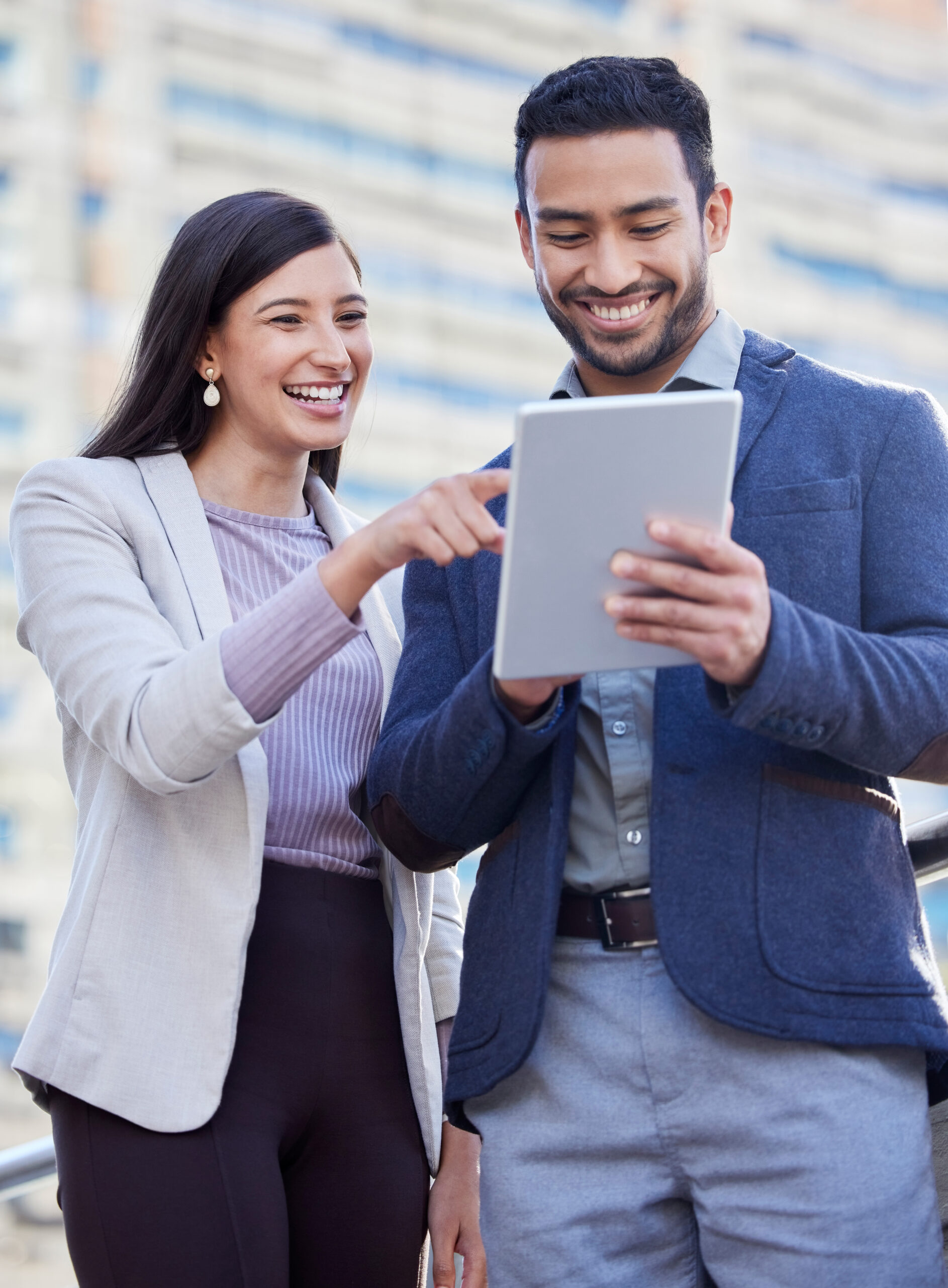 two coworkers using ipad smiling